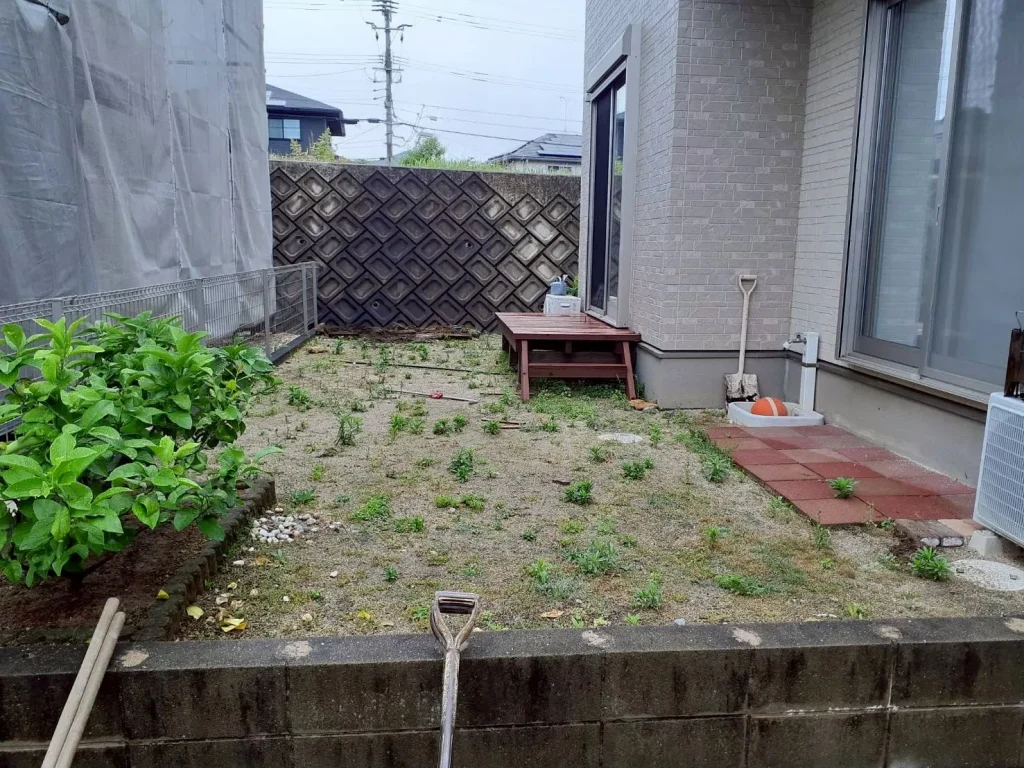 施工前の庭。雑草が点在し土がむき出しになった状態